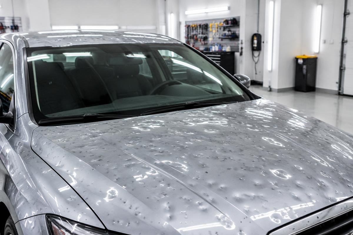Silver car hood and roof covered in hail dents at Eastern Auto Works in Cambridge, MD